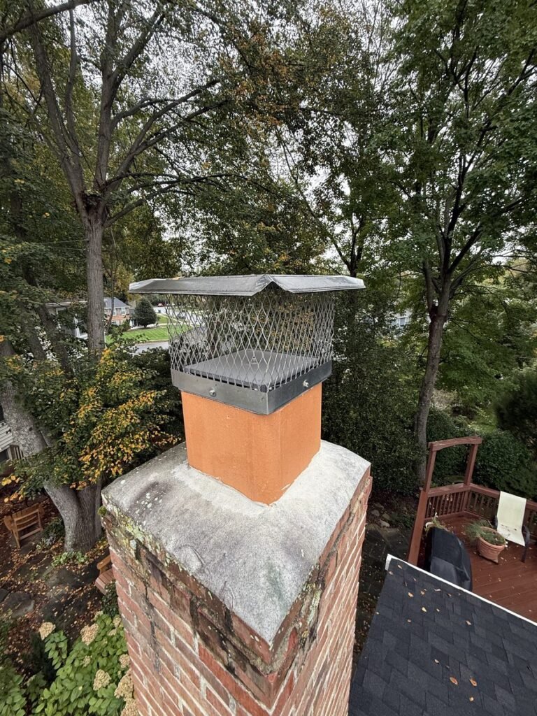 Stainless steel mesh chimney cap on a single clay flue tile on top of a brick chimney